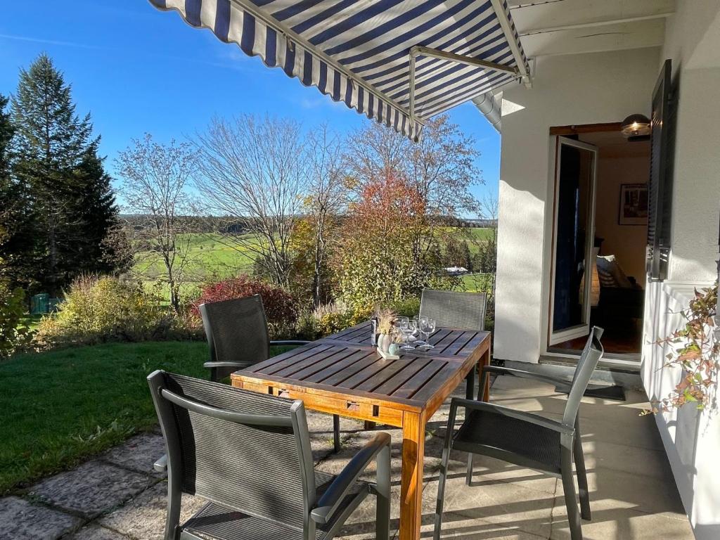 Une table et des chaises en bois sont disponibles sur la terrasse. dans l'établissement Holiday Home Westfalen by Interhome, à Dittishausen