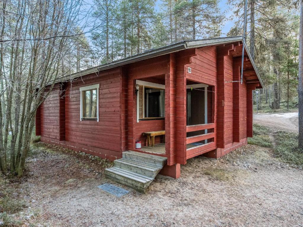 a red tiny house in the woods with stairs at Holiday Home Viipusjärvi 10 by Interhome in Ruka