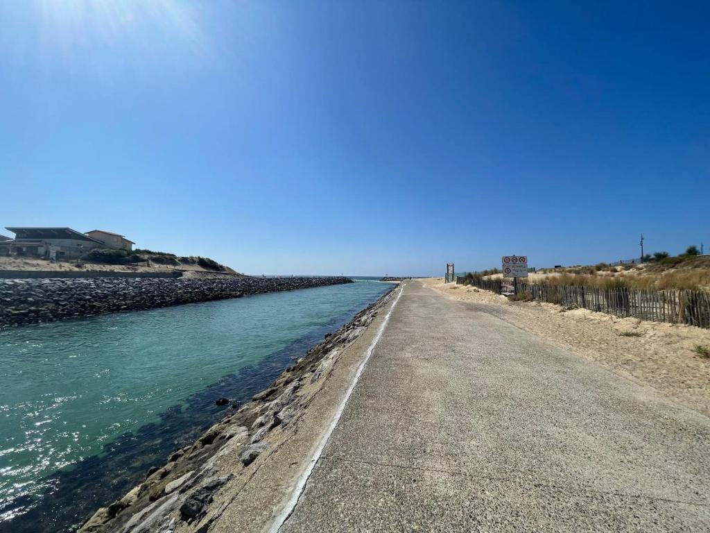 a road next to a body of water at Apartment L&#39;Oustalet-3 by Interhome in Mimizan-Plage