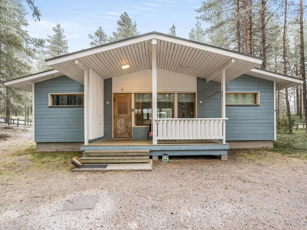 a small blue house with a porch and a door at Holiday Home Villa hilla by Interhome in Kuusamo