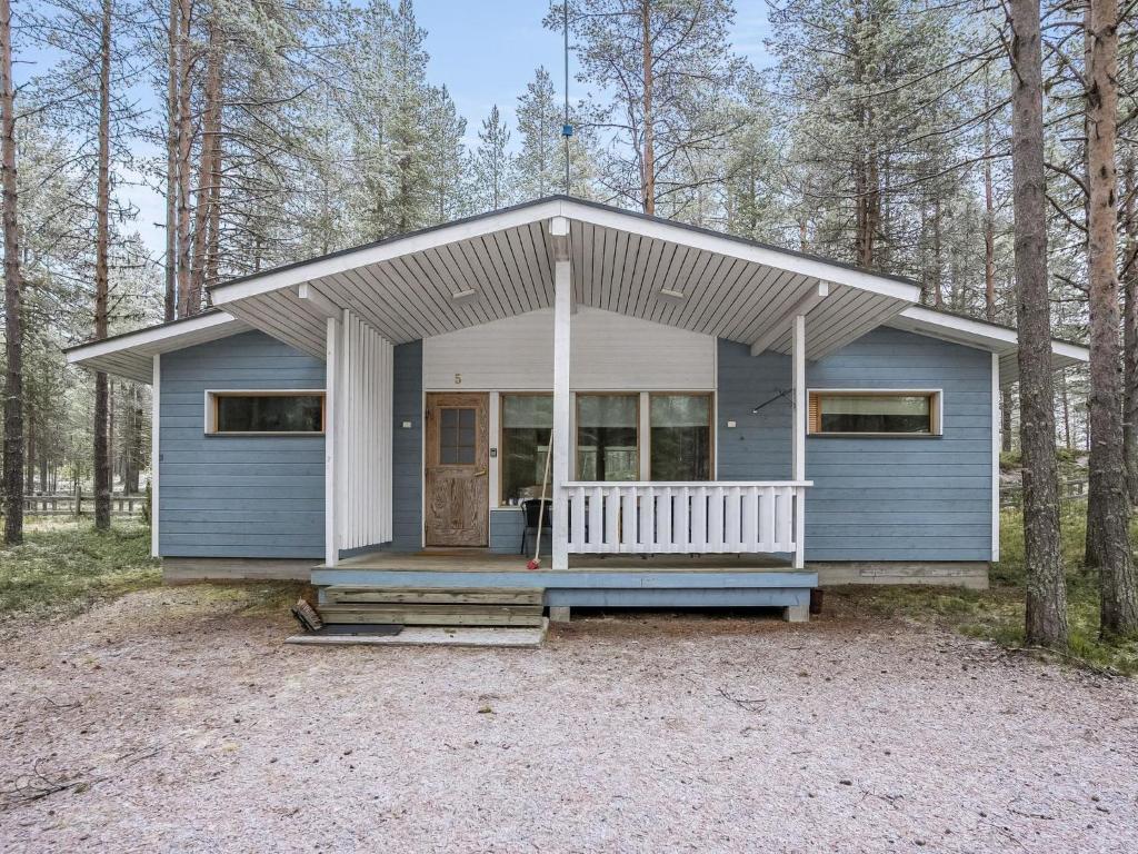 ein kleines blaues Haus mit einer Veranda im Wald in der Unterkunft Holiday Home Villa lakka by Interhome in Kuusamo