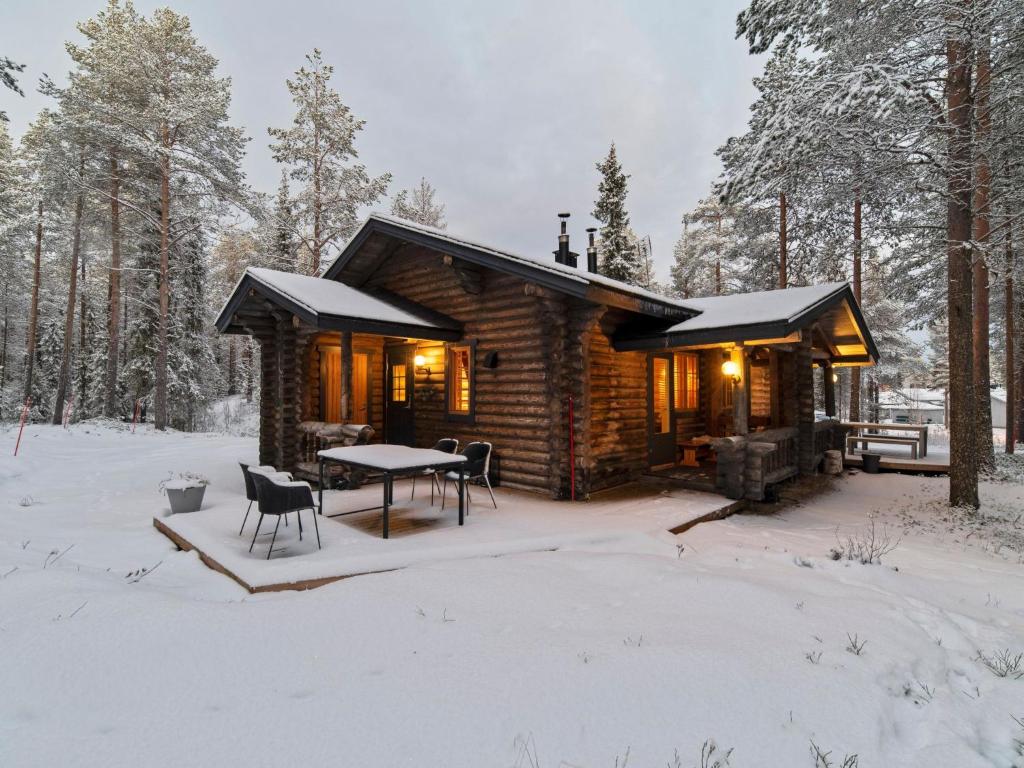 uma cabana de madeira com uma mesa na neve em Holiday Home Felixinpolku 2 by Interhome em Ylläsjärvi