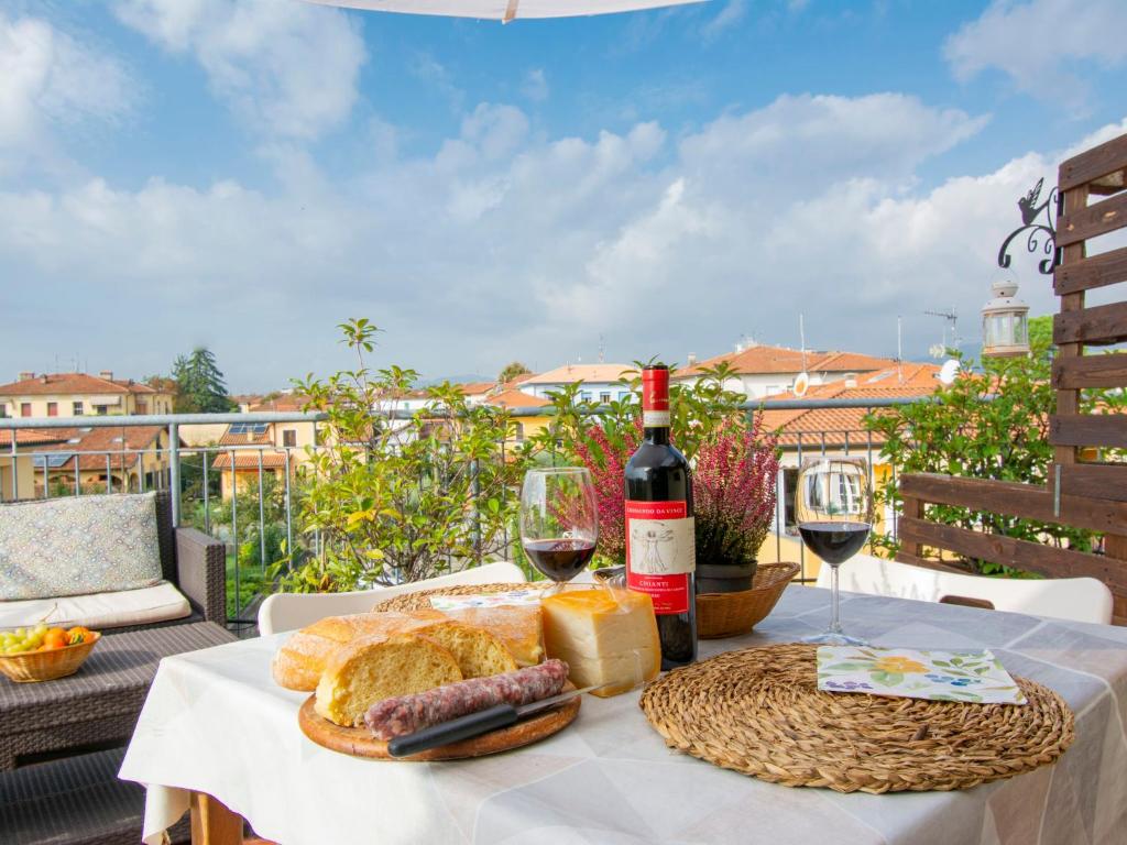 stół z butelką wina, chlebem i kieliszkami do wina w obiekcie Apartment La Rondine - LUU280 by Interhome w Lukce