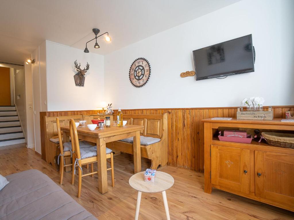 ein Esszimmer mit einem Tisch und einem TV an der Wand in der Unterkunft Apartment Les Lauzes D12 by Interhome in Les Menuires