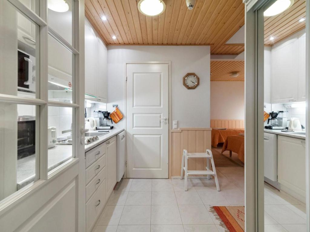 アカスロンポロにあるHoliday Home Yllästar 1 as 209 - la-la by Interhomeの白いキャビネットと壁掛け時計付きのキッチン
