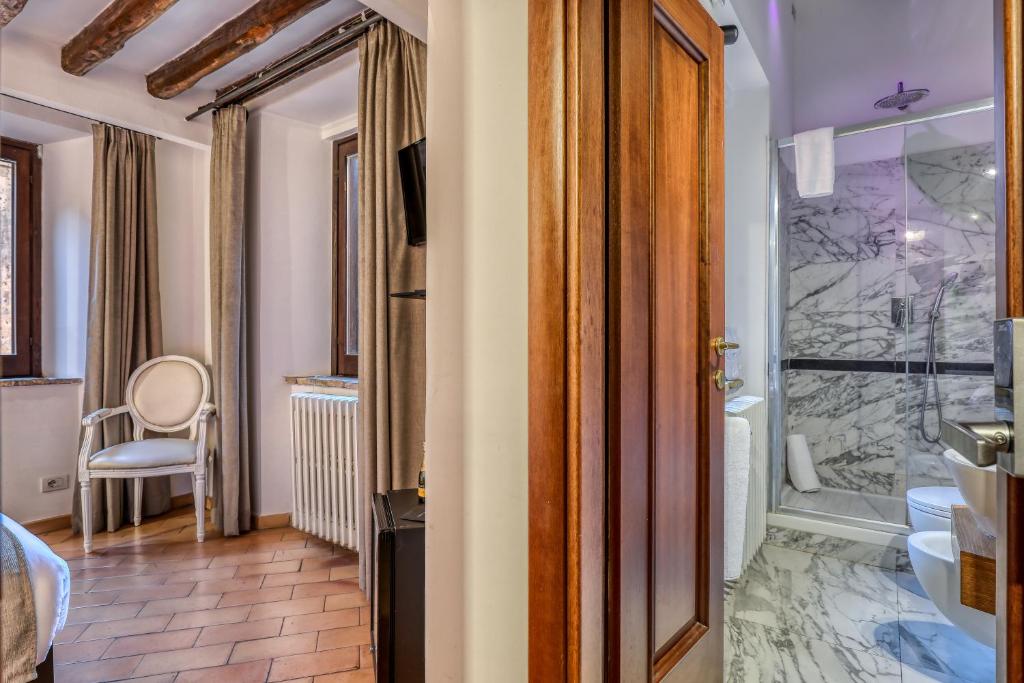 La salle de bains est pourvue d'une douche à l'italienne et d'une douche en verre. dans l'établissement Luxury Navona, à Rome