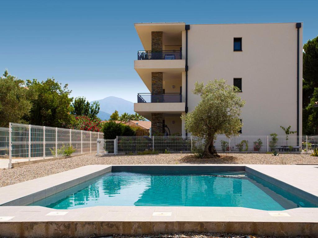 a villa with a swimming pool in front of a building at Apartment Le Clos des Alberes-1 by Interhome in Argelès-sur-Mer