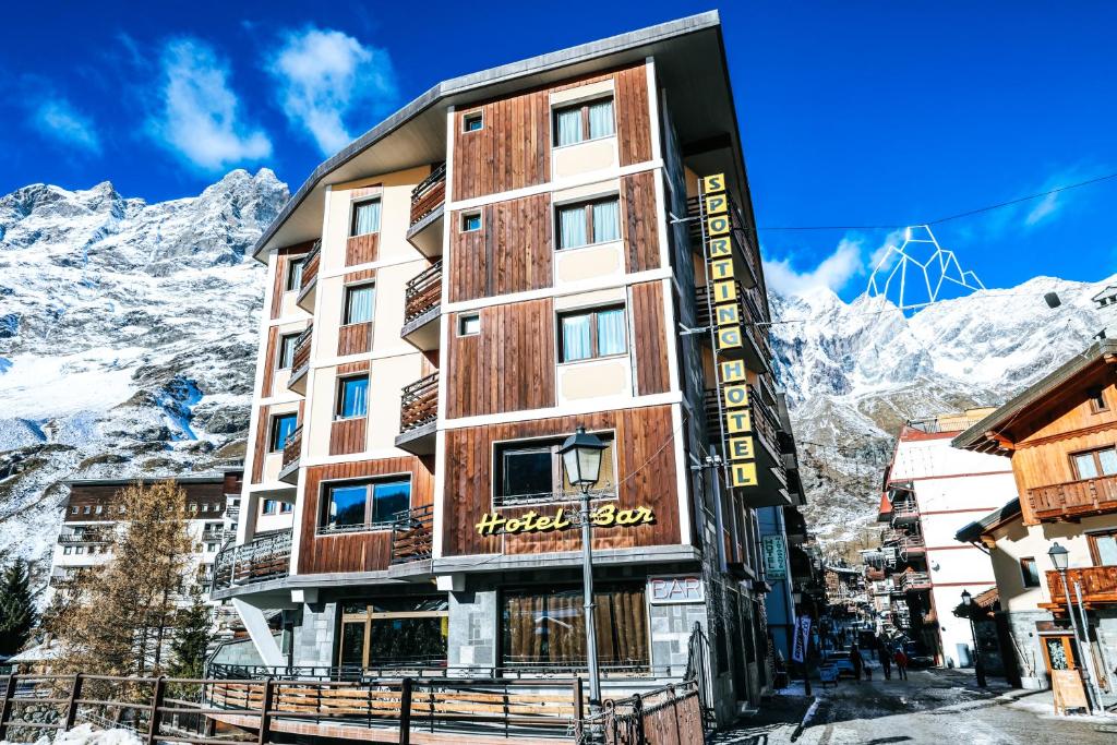 um hotel nas montanhas com montanhas ao fundo em HOTEL SPORTING em Breuil-Cervinia