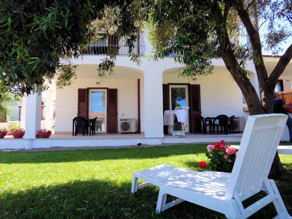 een witte stoel zittend onder een boom in een tuin bij Apartment K Plus by Interhome in Valledoria