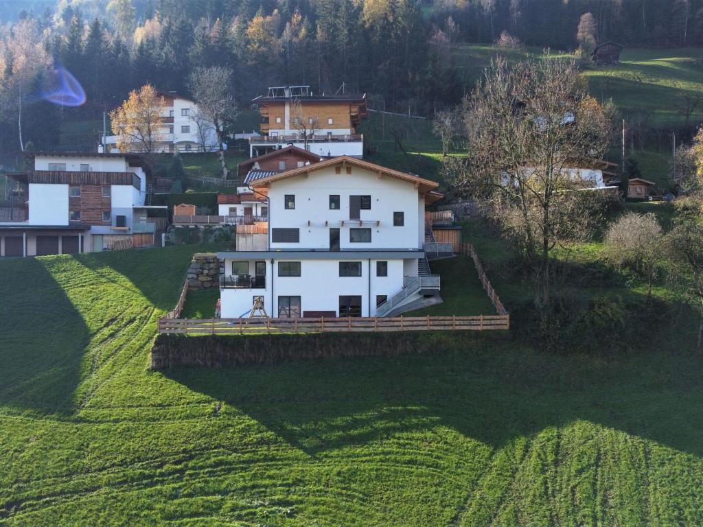 Biały dom na zielonym polu w obiekcie Apartment Georg by Interhome w mieście Kaltenbach