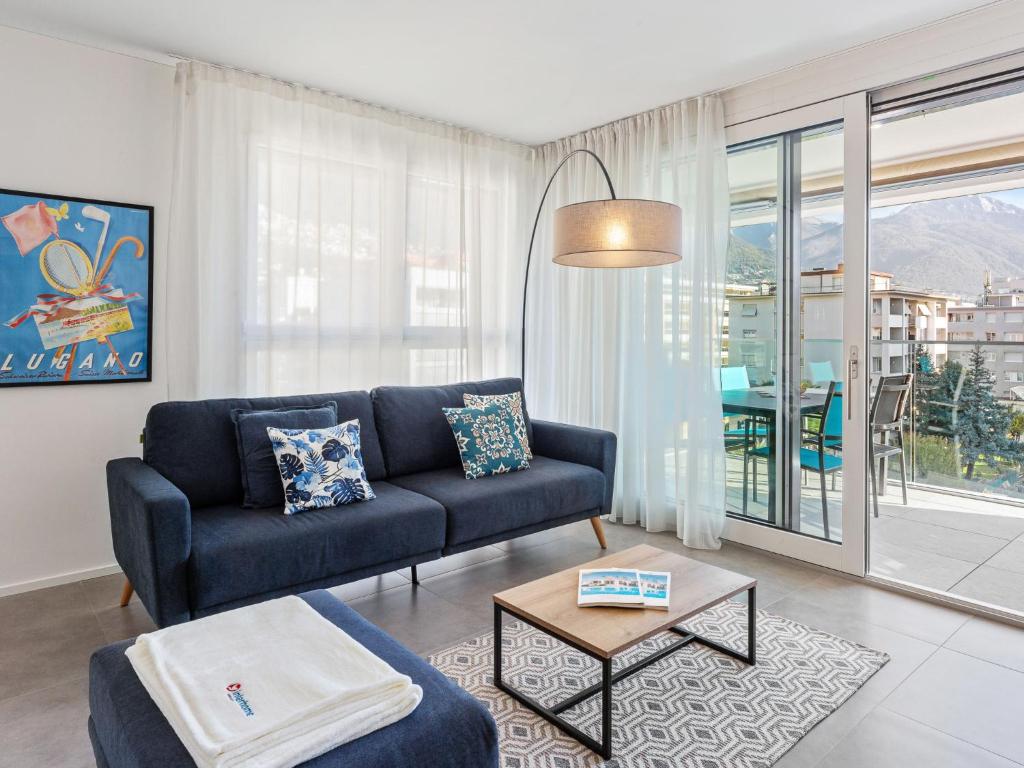 ein Wohnzimmer mit einem Sofa und einem Tisch in der Unterkunft Apartment LocTowers A3-3-3 by Interhome in Locarno