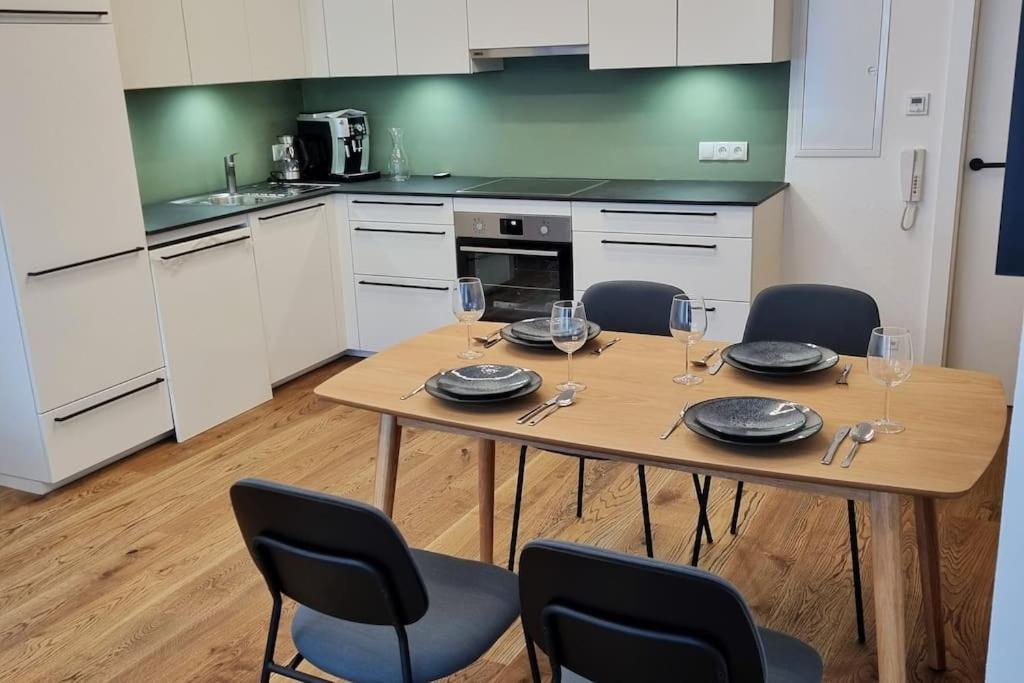 a kitchen with a table and chairs with wine glasses at Appartment Wolf Huber im Zentrum der Altstadt. in Feldkirch