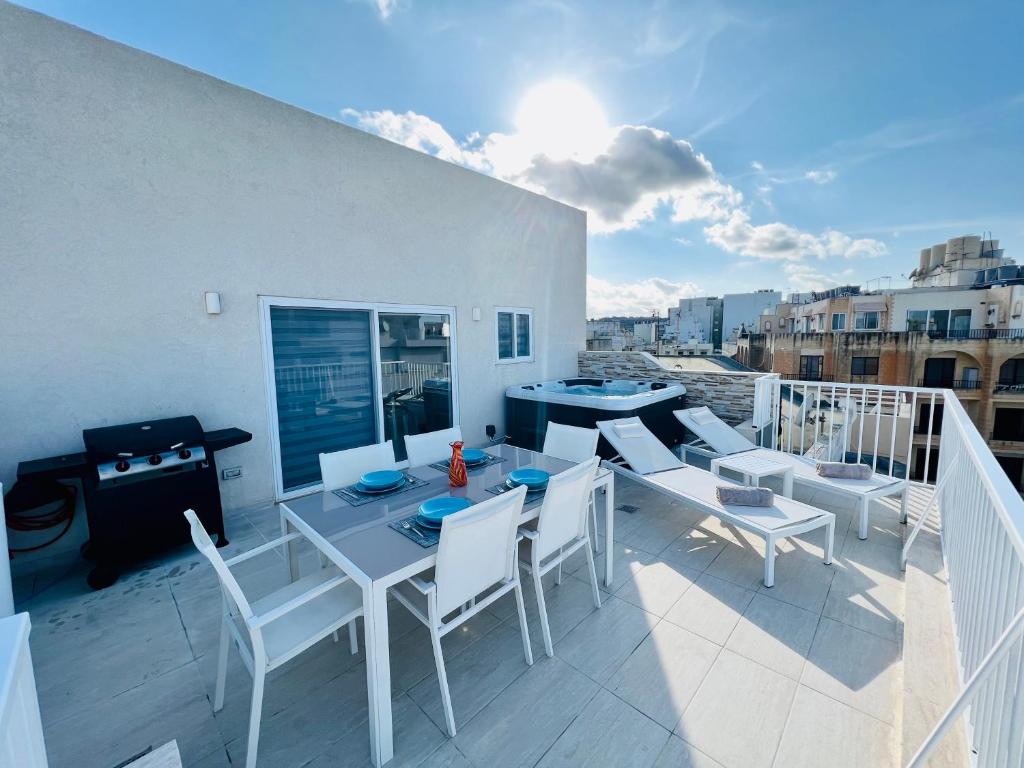 a balcony with a table and chairs on a roof at Poseidon Court Penthouse SUPERIOR in St Paul's Bay