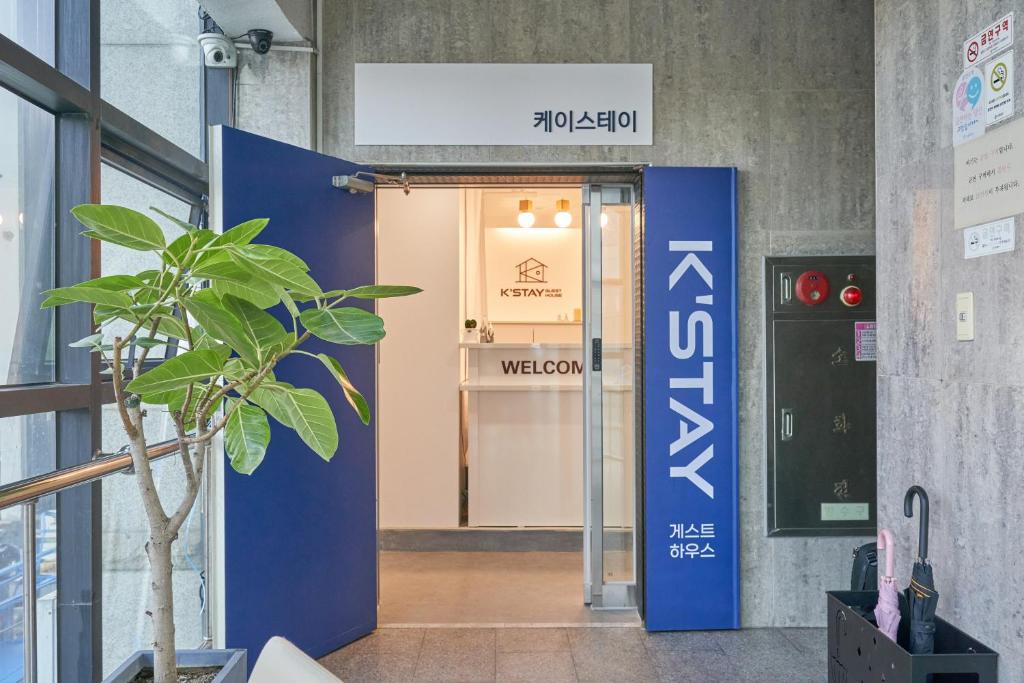 una puerta abierta a una señal de bienvenida en un edificio en K'STAY Sinchon, en Seúl