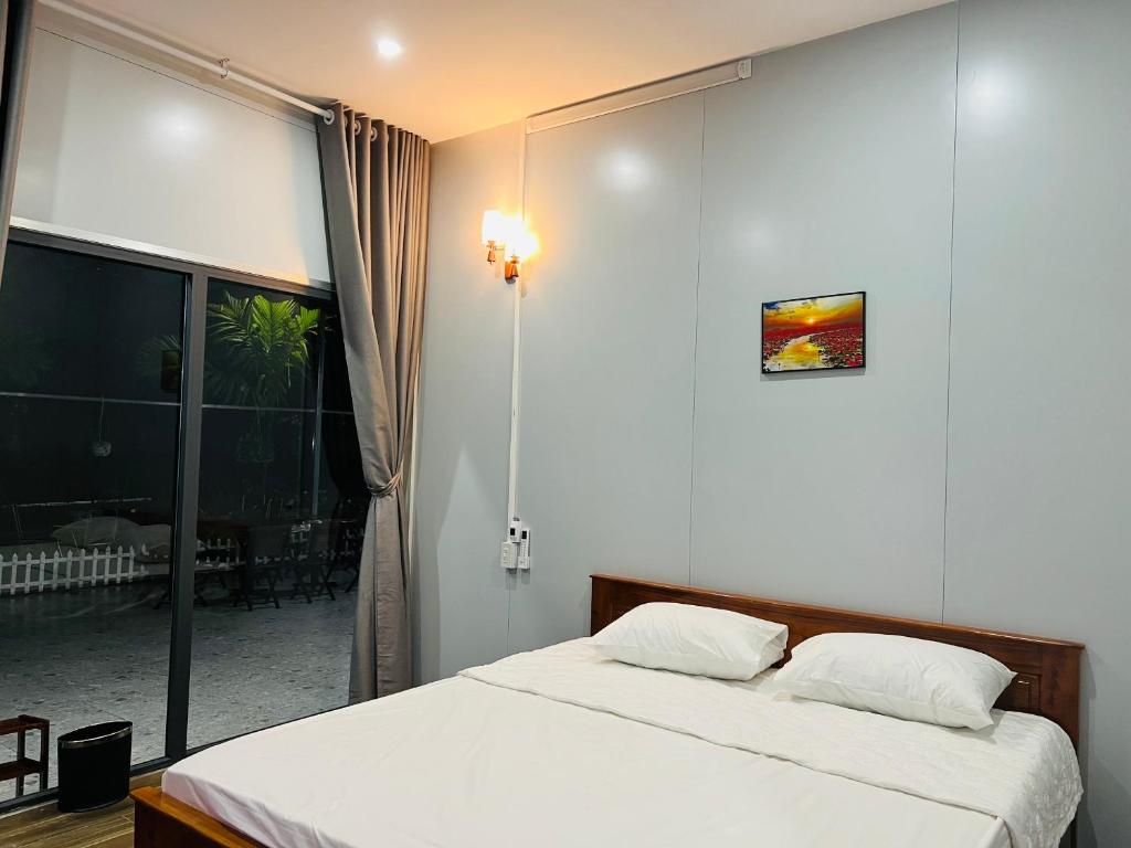 a bedroom with a bed and a large window at SuMin Homestay in Phú Quốc
