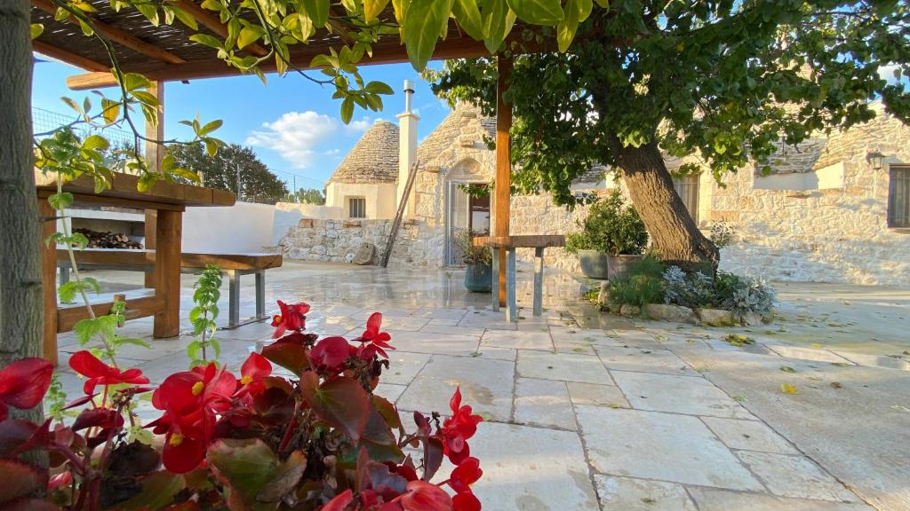 a garden with red flowers in front of a building at Trullo Incanto in Ostuni