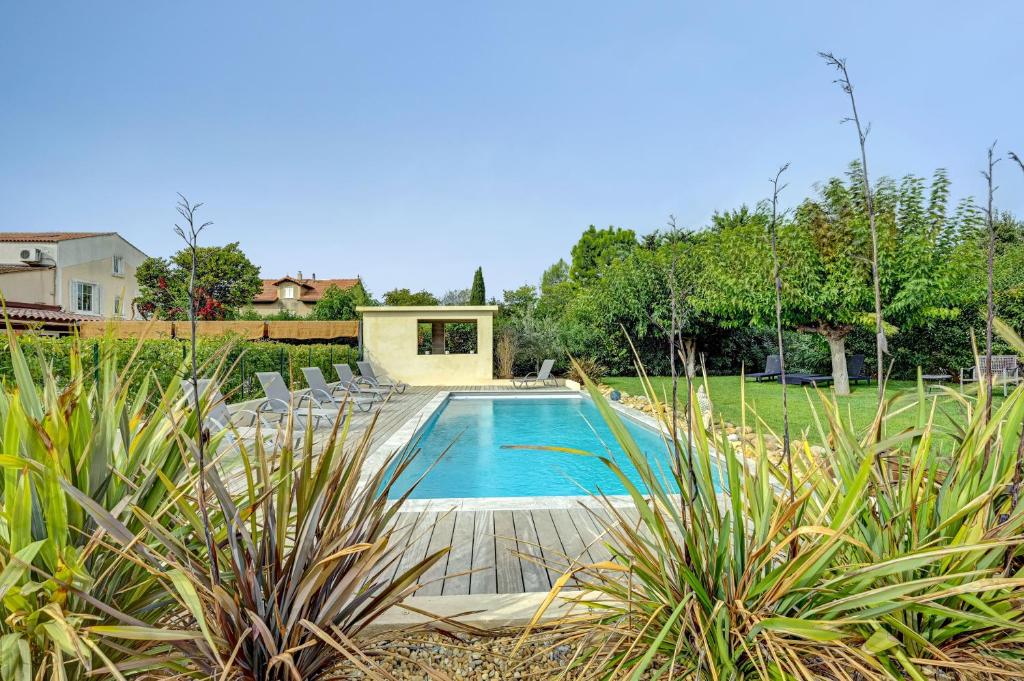 a swimming pool in a yard with chairs at Le Provence in Gémenos