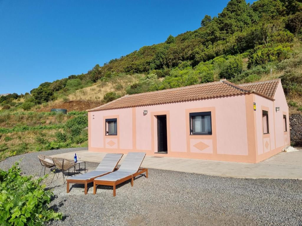 a small pink building with two benches and a table at villa los vaqueros in Garafía