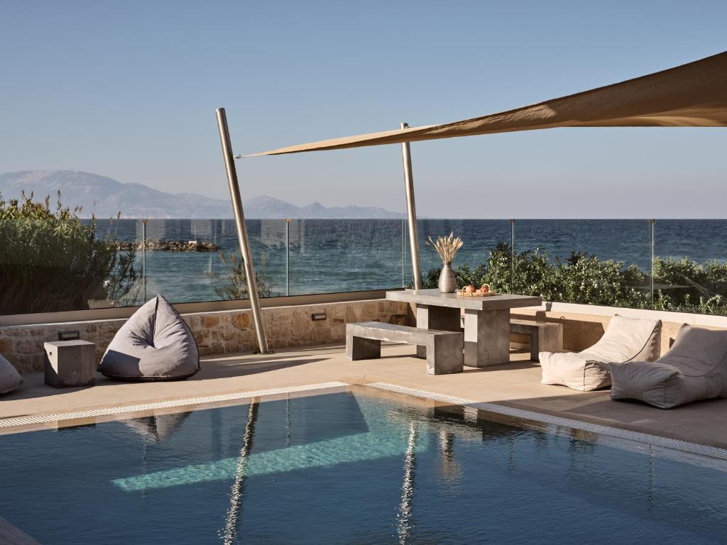 a swimming pool with a table and a picnic table next to the water at LaLune SeaSide Villa, Zante Zen By ThinkVilla in Kipseli
