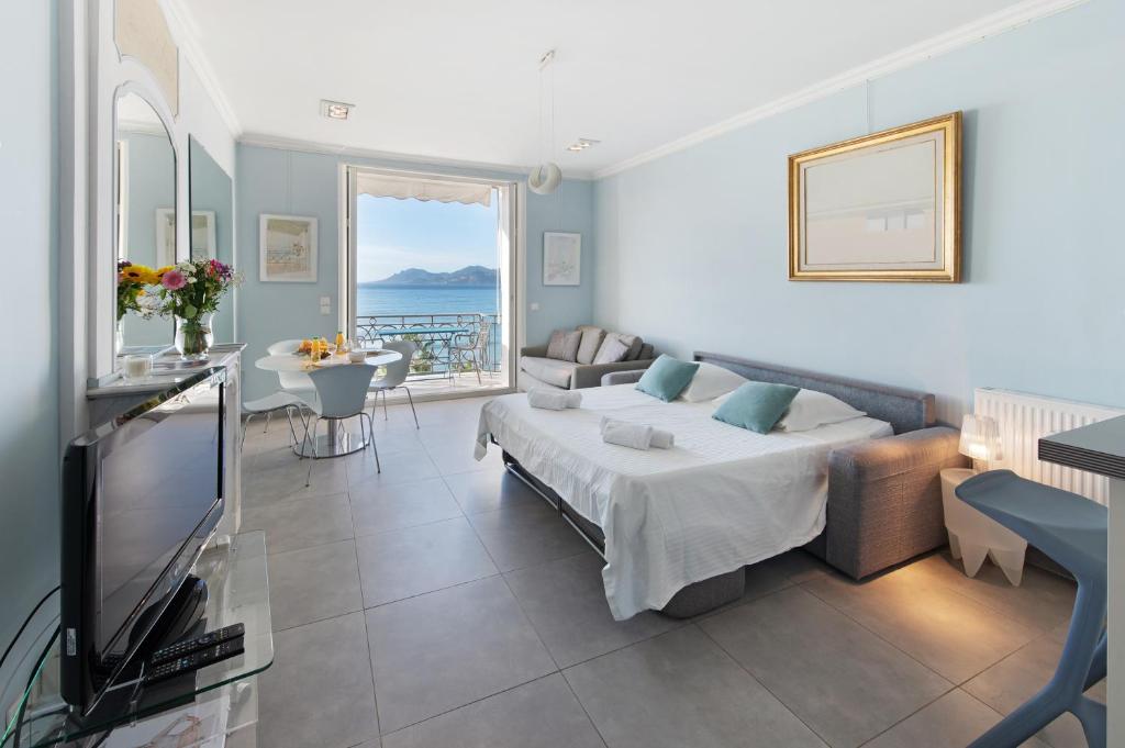 - un salon avec un lit et une télévision dans l'établissement Palais Miramar - Suite Blue Room - Vue Mer -Croisette Emplacement Unique - 20M Plage - WIFI - Clim, à Cannes