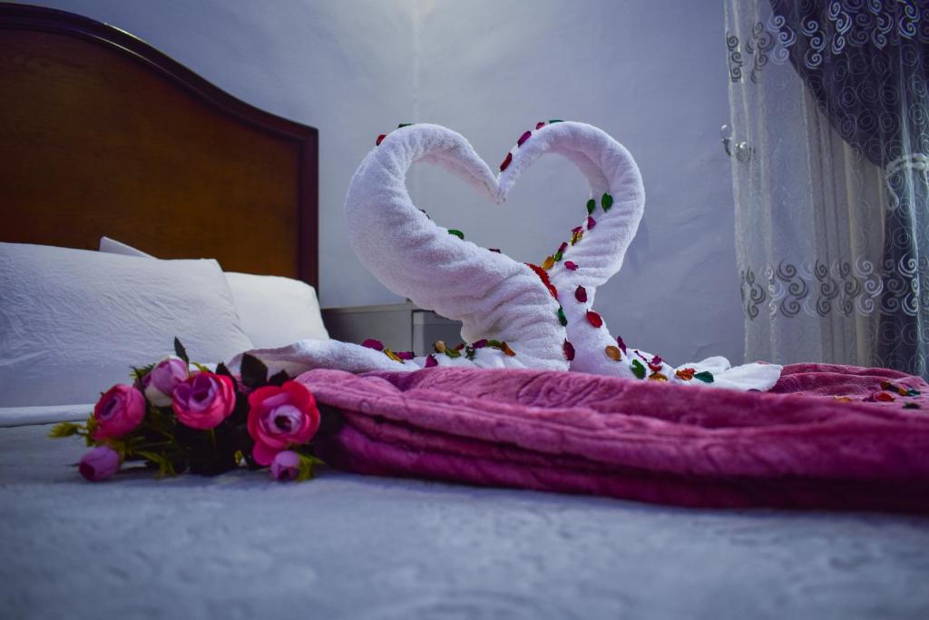 Una cama con una toalla en forma de corazón en Crown Hotel en El Cairo