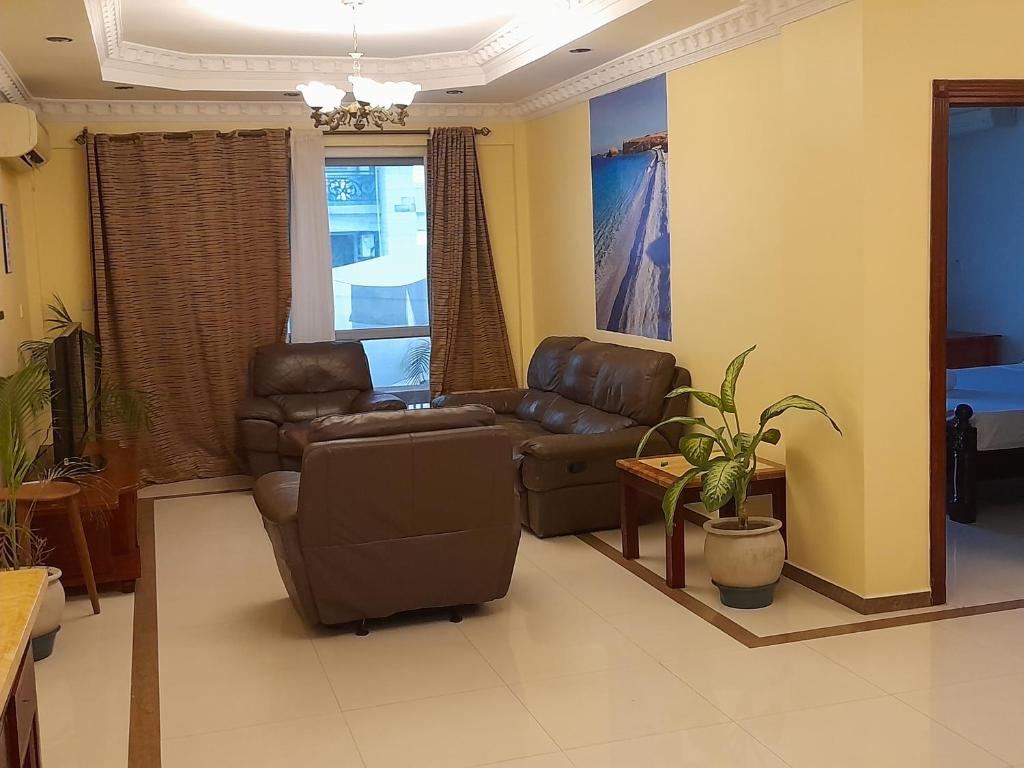 sala de estar con 2 sillas y sofá en Starwood Apartment en Dar es Salaam