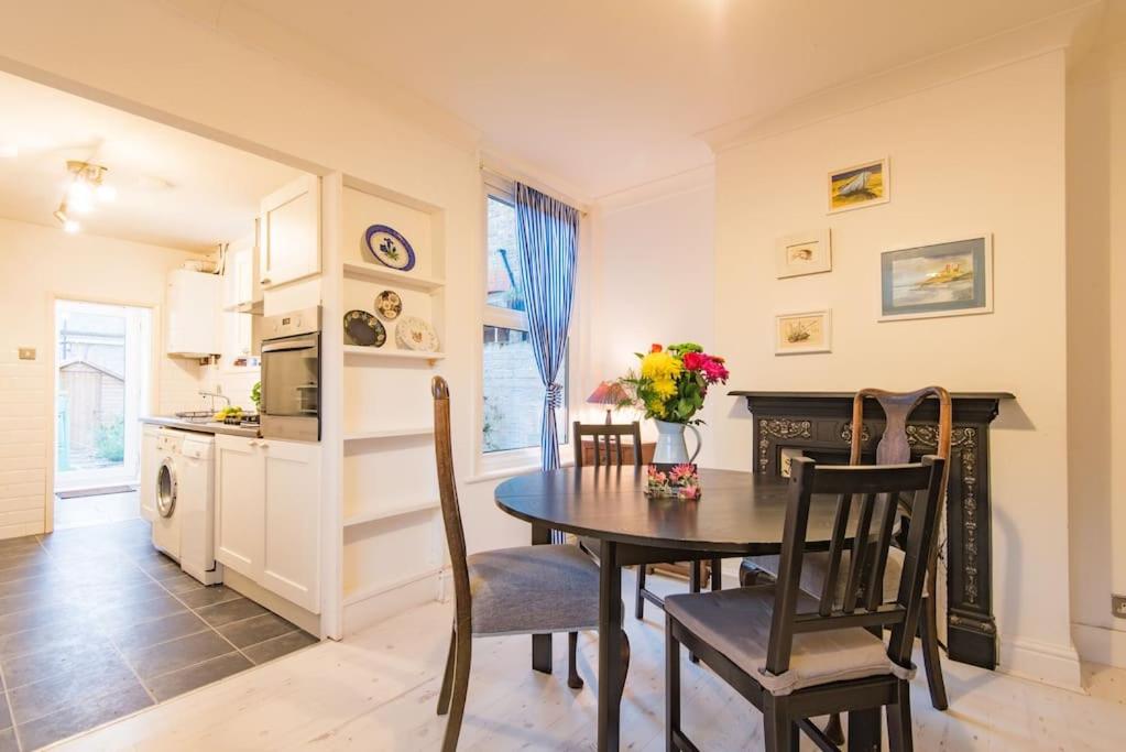 a kitchen and dining room with a table and chairs at Honeysuckle Cottage in Whitstable