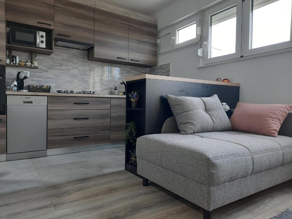 uma sala de estar com um sofá e uma cozinha em Apartman Ines em Velika Gorica