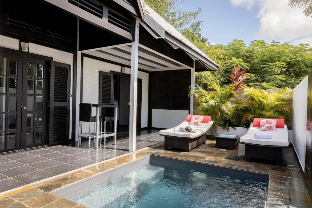 a house with a swimming pool in front of a house at Domaine de la Palmeraie in Le Diamant