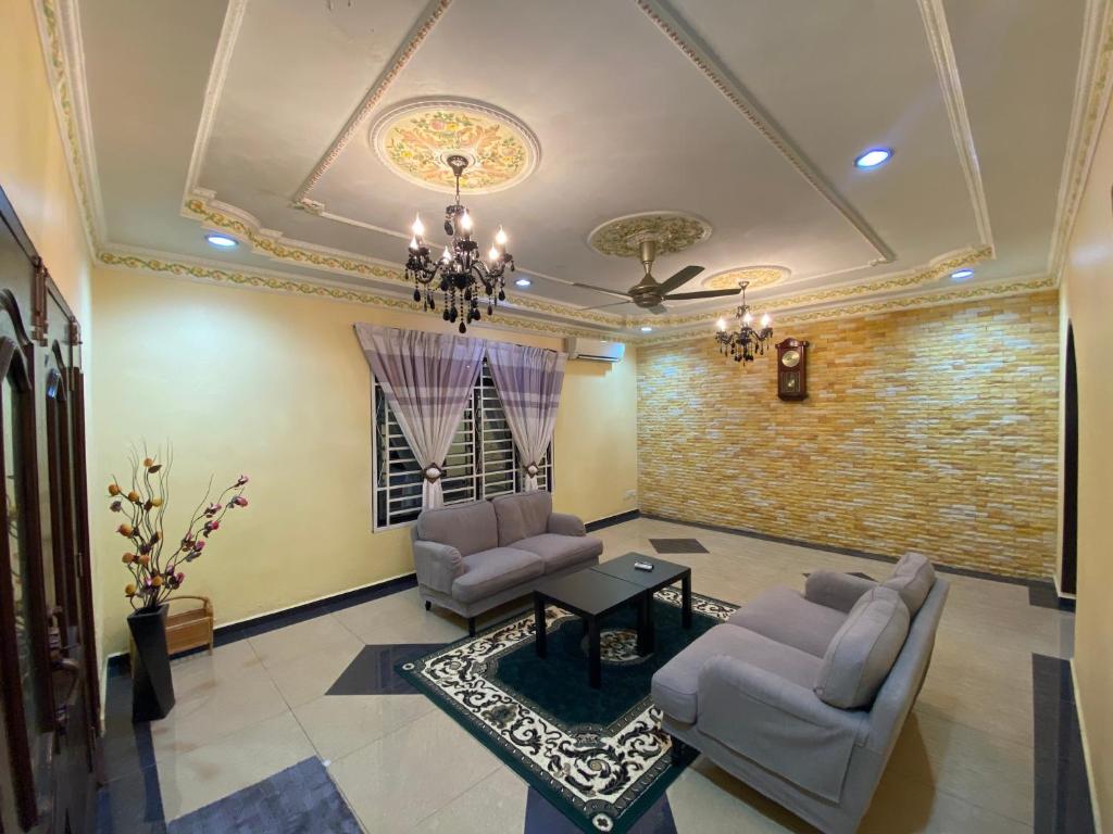 a living room with two chairs and a ceiling at D'Village Batu Berendam, Melaka in Ayer Keroh