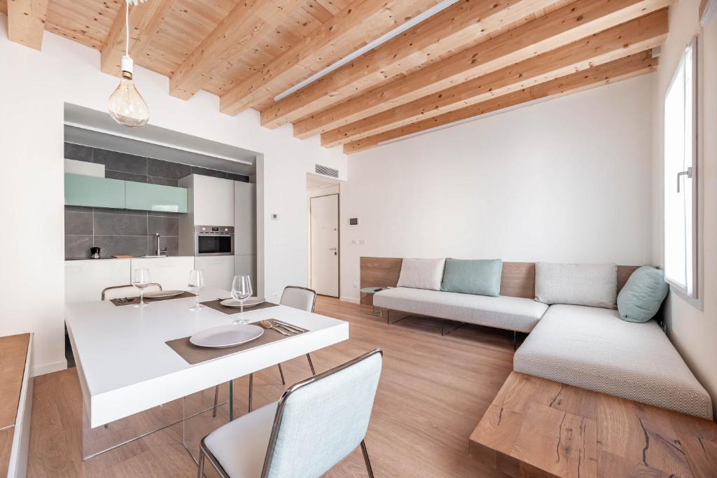 Palazzo '900 Design Flats - Il Pittore في بادوفا: غرفة معيشة مع أريكة وطاولة