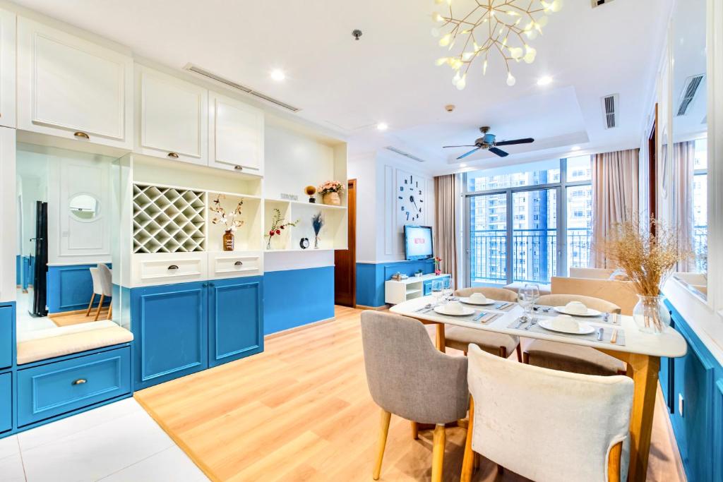 a kitchen with blue cabinets and a table with chairs at Moxy HCMC Aparts - Vinhomes Central Park, Ice Rink in Ho Chi Minh City
