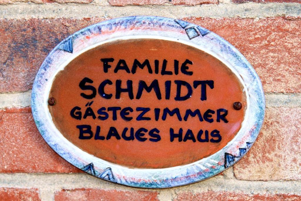 una placa en una pared de ladrillo con las palabras Famille ardilla mira martillo en Blaues Haus, en Glückstadt