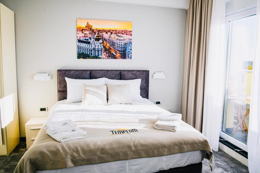 une chambre d'hôtel avec un lit avec une photo sur le mur dans l'établissement Templum apartments - Slavija square, à Belgrade