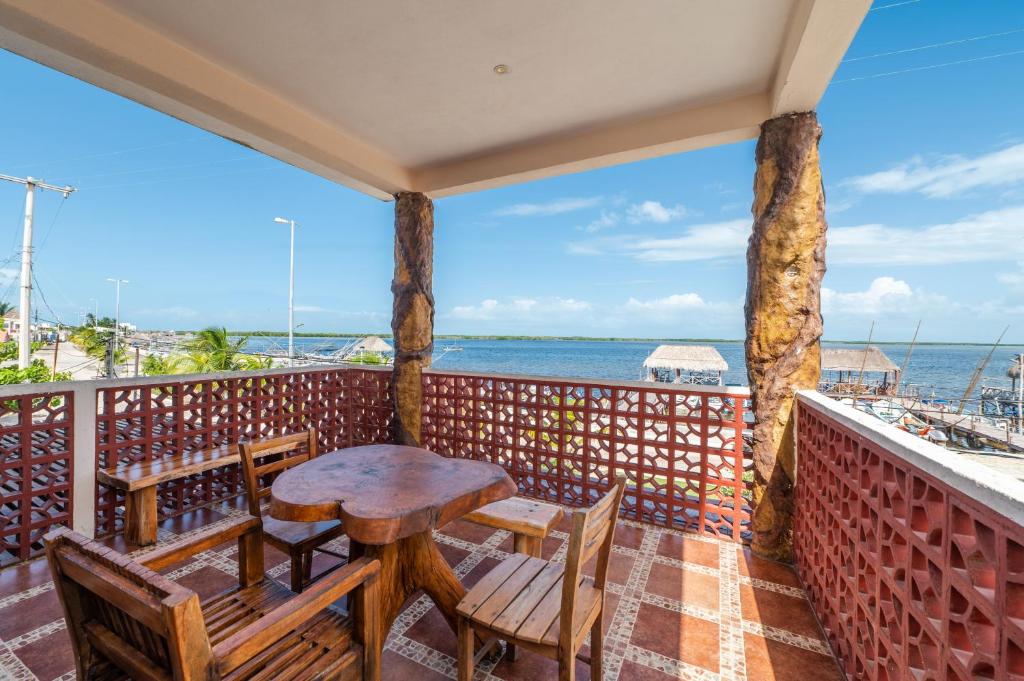 a balcony with a table and chairs and the ocean at Posada El Perico Marinero in Río Lagartos