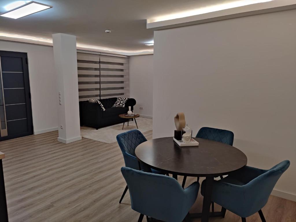 ein Wohnzimmer mit einem Tisch, Stühlen und einem Sofa in der Unterkunft Exklusiv, modernes Apartment in Sachsenheim