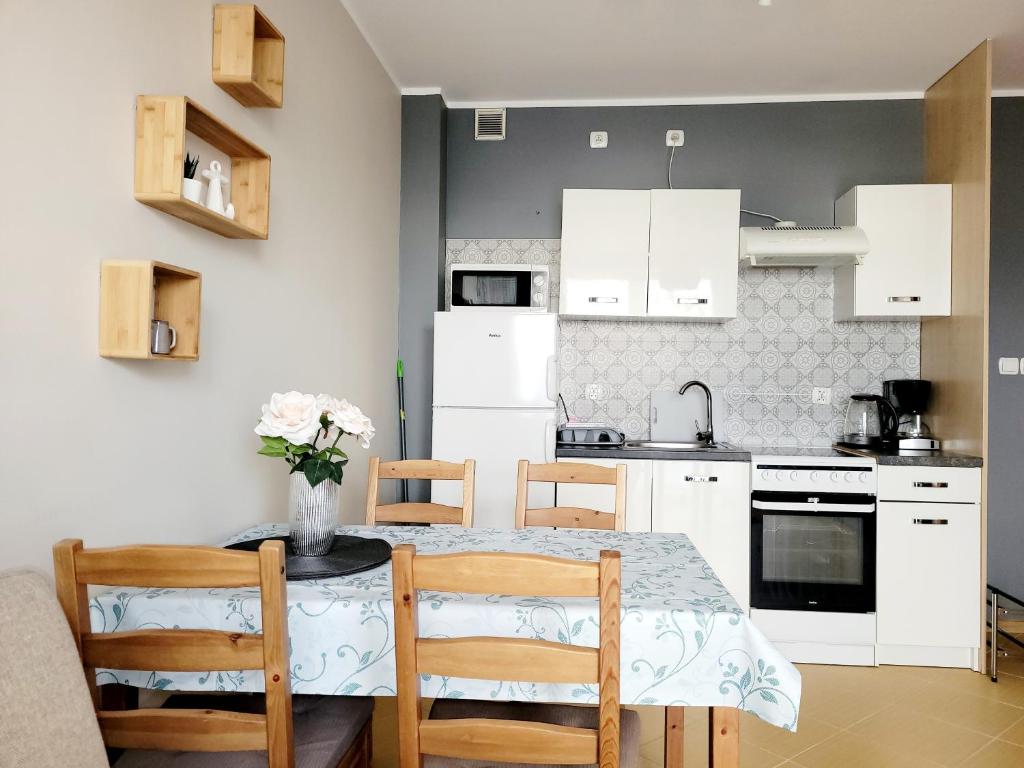 a kitchen with white cabinets and a table and chairs at ALIZE in Reda