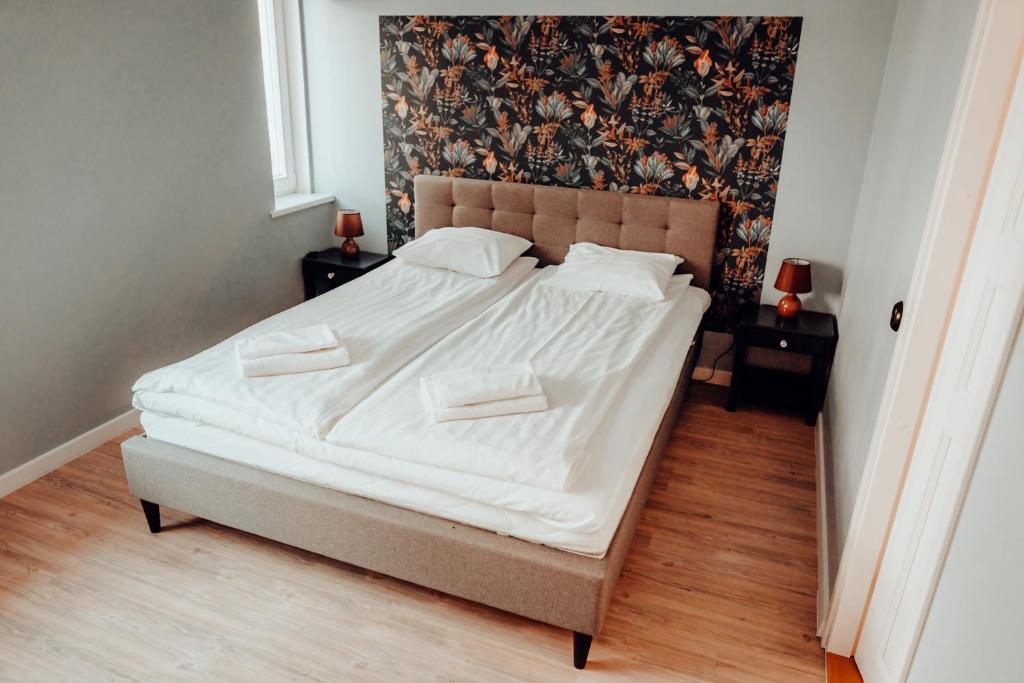 Una cama con sábanas blancas y almohadas en un dormitorio en Central 1-bedroom Apartment with Bath & Balcony, en Tallin