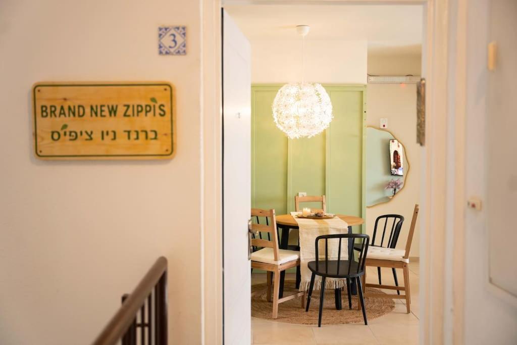 Brand New Zippi`s- karmiel في كرمئيل: غرفة طعام ومطبخ مع علامة مكتوب عليها المناديل جديدة تنزل