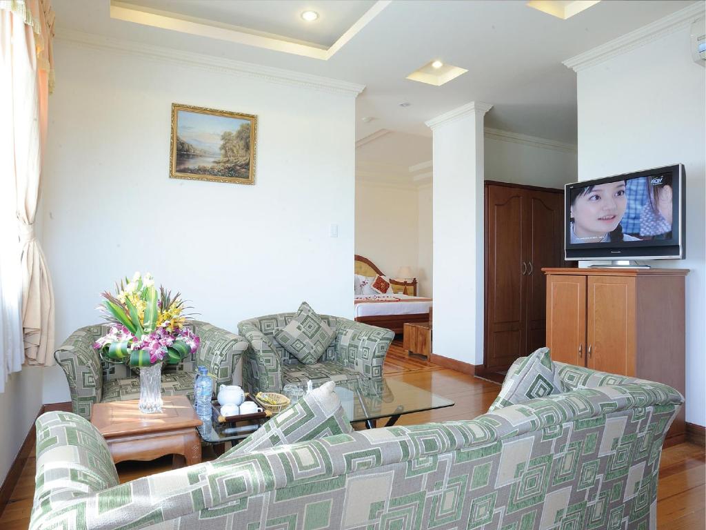 a living room with two couches and a tv at Hoang Yen Hotel in Thuan An