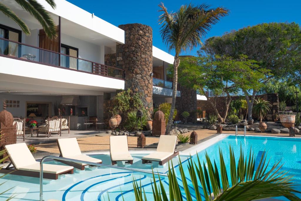 a villa with a swimming pool and a resort at Villa VIK - Hotel Boutique in Arrecife