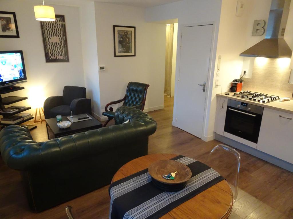 salon ze skórzaną kanapą i stołem w obiekcie Appartement calme en plein centre ville w mieście Granville