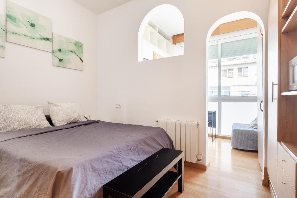 a white bedroom with a bed and a window at Double room with private bathroom and private kitchen in Barcelona