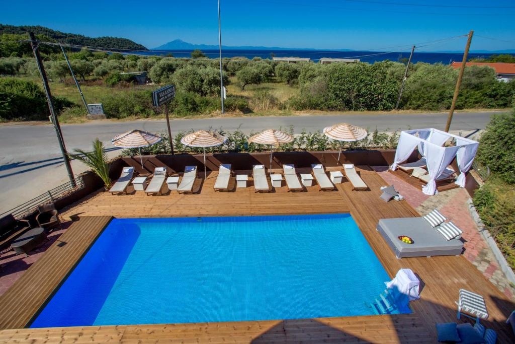 a pool with chaise lounge chairs and a swimming pool at Kapahi Magic Hotel Apartments in Potos