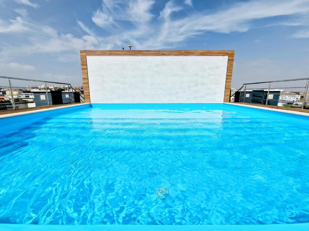 una gran piscina de agua azul con una pizarra blanca en Praia Modern Apartment vista Mar en Praia