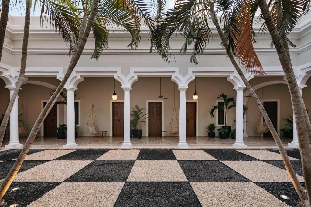 a lobby with palm trees and a checkered floor at DECU DOWNTOWN in Mérida