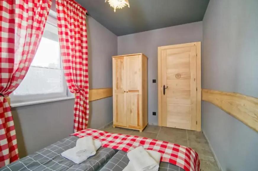 sypialnia z łóżkiem, oknem i drzwiami w obiekcie Apartamenty Koniaków Residence w mieście Koniaków