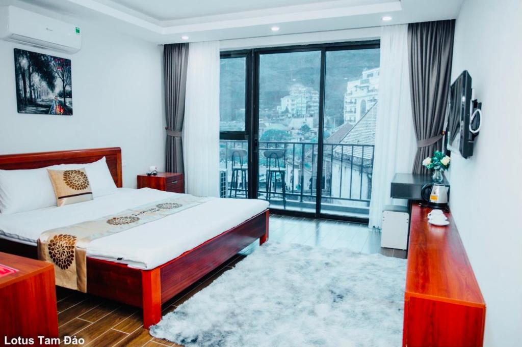 um quarto de hotel com uma cama e uma grande janela em Lotus Tam Đảo Hotel em Tam Dao
