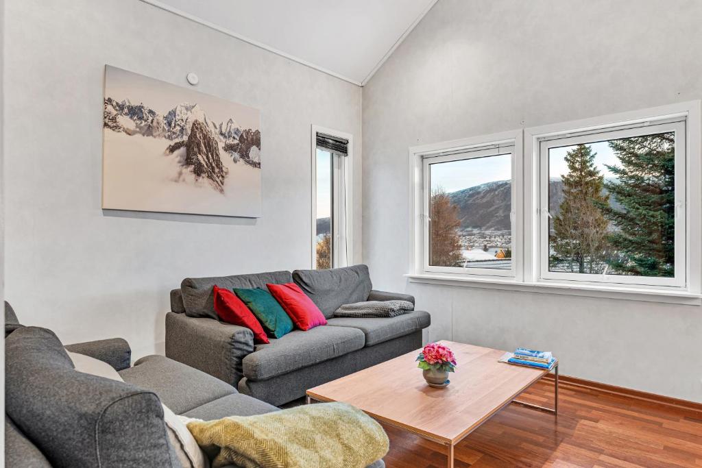 a living room with a couch and a table at Auroras Friends Apartment in Tromsø