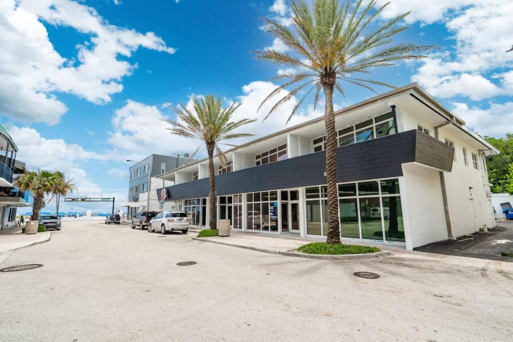 un edificio con palmeras delante en The Purple Pelican Beachfront with Ocean Balcony Unit 1, en Fort Lauderdale